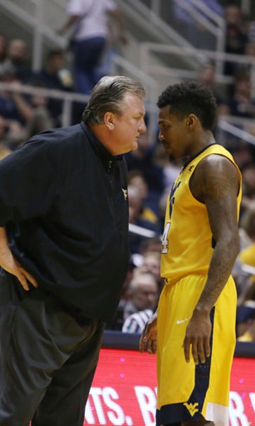 WVU's Huggins falls in apparent health scare, stays on bench